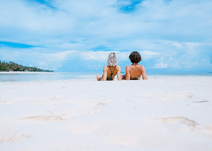 A couple laying on the beach watching the water