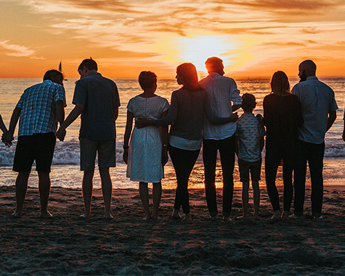 A large family looking at a sunset on the beach